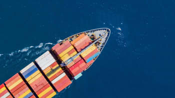 An ariel view of a cargo ship sailing through the ocean