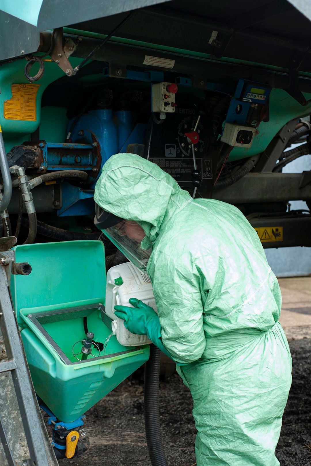 Pouring liquid into a tank wearing appropriate clothing