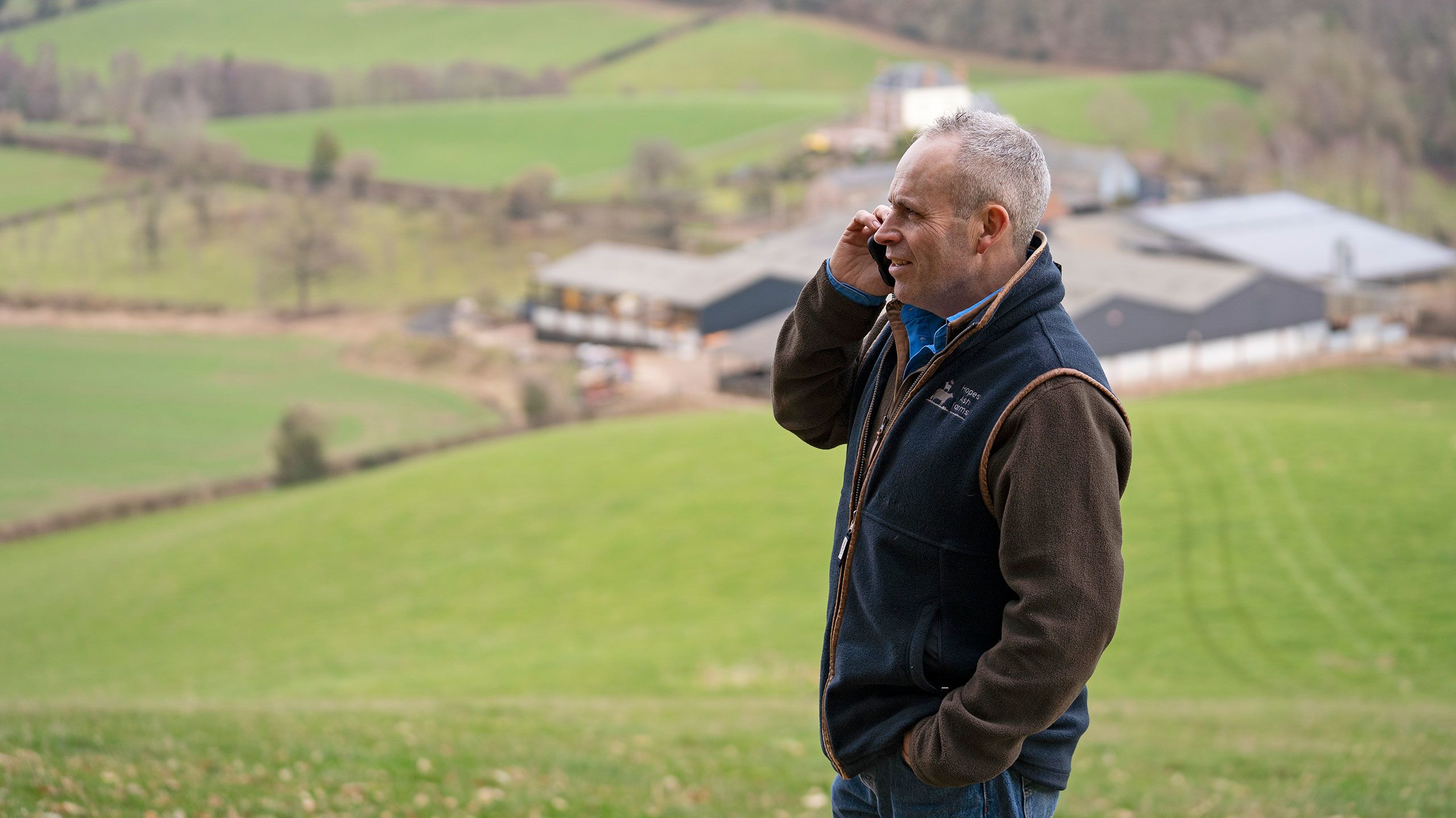 Man speaking on a phone in a field